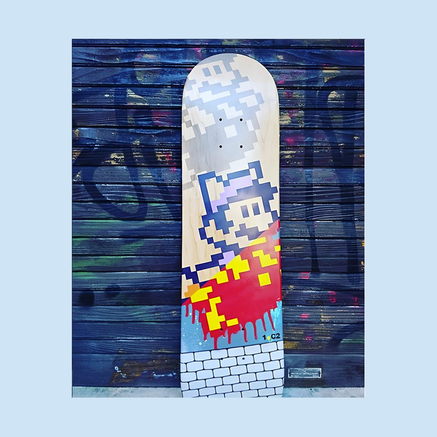 Planche de skateboard Mario pixelisée contre un mur graffiti. Art urbain et nostalgie rétro.